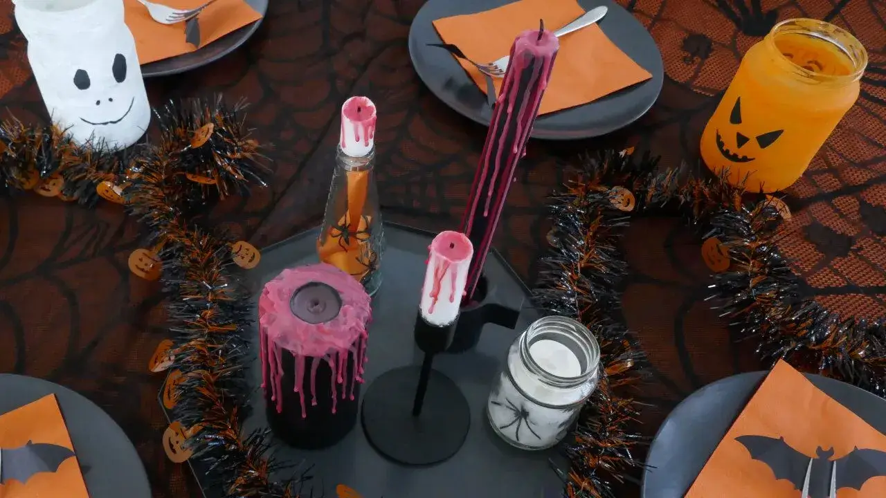 Halloween-Tischdeko mit Kerzen, Windlichtern, Spinnennetz-Tischdecke und Kürbismotiven Halloween-Tisch mit Kerzen, Girlanden, Geister- und Kürbis-Windlichtern, Spinnennetz-Tischdecke und orange-schwarzen Platzdeckchen.